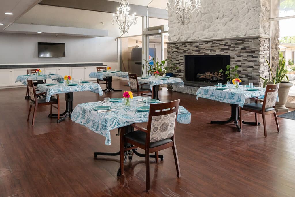 View of dining hall with a big fireplace, tv and six tables